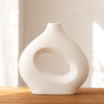 Casă modernă cu fațadă albă și geamuri mari, amplasată într-o zonă verde.