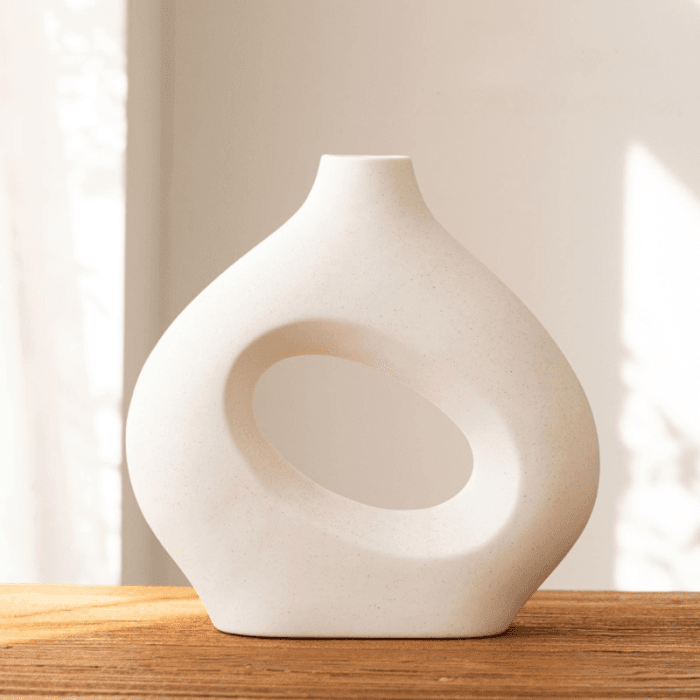 Casă modernă cu fațadă albă și geamuri mari, amplasată într-o zonă verde.