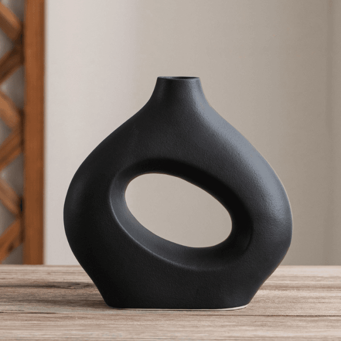 Living room modern cu canapea gri, măsuță de cafea din lemn și decorațiuni minimaliste.